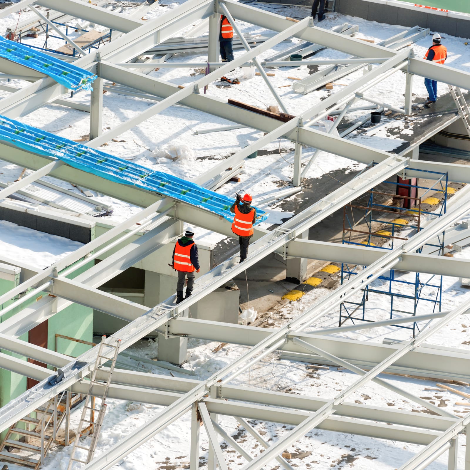Workers building a roof structure on a construction site